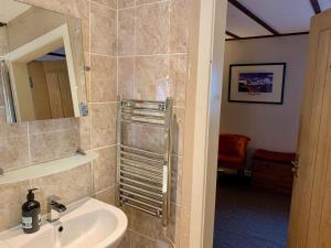 a bathroom with a sink and a mirror at Lochindaal Hotel in Port Charlotte