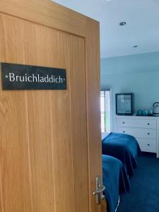 a door with a sign on it in a bedroom at Lochindaal Hotel in Port Charlotte