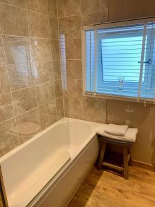 a bath tub in a bathroom with a window and a window at Lochindaal Hotel in Port Charlotte