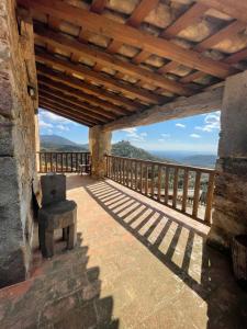 une terrasse couverte avec un toit en bois offrant une vue sur l'océan. dans l'établissement Requesens, à La Jonquera