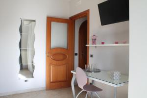 um quarto com uma mesa e uma porta de madeira em B&B Vesuvio Smiling em Ercolano