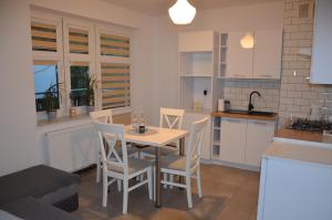a kitchen with a table and chairs in a room at Apartamenty Willa Pogoń in Krynica Zdrój