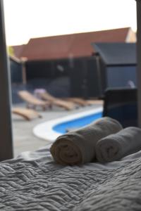 ein rollendes Handtuch auf einem Bett vor dem Pool in der Unterkunft Kuća za odmor Maja in Ðakovo