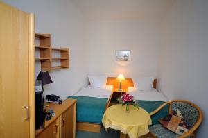 una habitación con 2 camas y una mesa con un jarrón. en Mini-1-Raum-Apartment mit eigenem Eingang, en Bad Doberan
