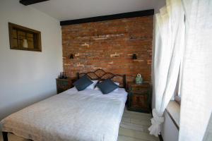a bedroom with a bed and a brick wall at ANTICA RESIDENZA TOSCANA in Dumbrăviţa