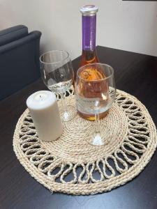 a candle and a bottle and glasses on a table at Apartament 2 camere in Chiajna
