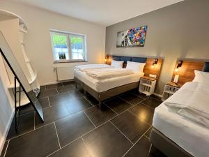 1 Schlafzimmer mit 2 Betten und einer Treppe in der Unterkunft JUNIPRO Luxury Apartments in Nohfelden