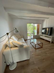 sala de estar con sofá blanco y mesa de cristal en Modern apartment with parking 2 min from the beach, en Calella de Palafrugell