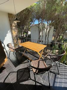a wooden table and chairs on a patio at Modern apartment with parking 2 min from the beach in Calella de Palafrugell