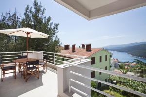 a balcony with a table and an umbrella at Casa M Rabac in Rabac