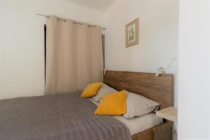 a bedroom with a bed with yellow pillows on it at Hill apartman - MAKSIMIR Rebro in Zagreb