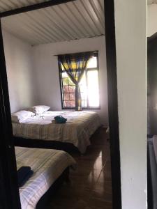 two beds in a room with a window at Casa en la Montaña in Macanal