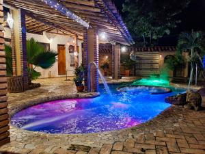 a pool with a waterfall in a backyard at night at Hotel Terra Barichara in Barichara