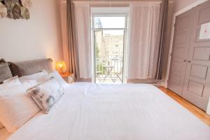 a bedroom with a large white bed with a window at ZEN - SelfCheckIn - Rooftop - Terraces - St-Denis in Montréal