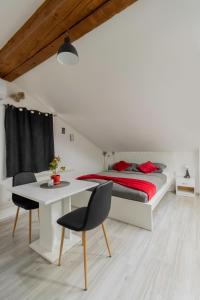 a bedroom with a bed and a table and chairs at Hill apartman - MAKSIMIR Rebro in Zagreb