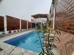 a swimming pool next to a brick building at CASA PLAYA REFUGIO AZUL in Cerro Azul