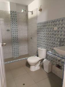 een badkamer met een toilet, een douche en een wastafel bij CASA PLAYA REFUGIO AZUL in Cerro Azul