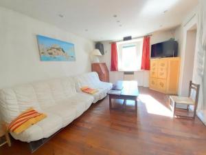 a living room with a white couch and a table at Gîte paisible au cœur des montagnes à Nohèdes in Nohèdes