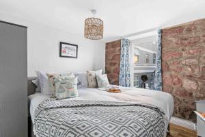 a bedroom with a bed with a brick wall at Quay Cottage - On back beach of Teignmouth in Teignmouth