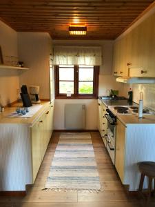 a kitchen with white cabinets and a wooden floor at Sävekulla 208 "Lillekulla" in Sävekulla