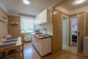 uma pequena cozinha com um lavatório e uma mesa em Nya Apartment em Sighisoara
