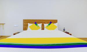 a bed with colorful sheets and pillows on it at Itsy By Treebo - Oasis Pride in Nashik