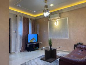 a living room with a couch and a television at RÉSIDENCE MARTHA in Yaoundé