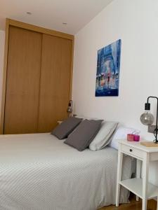 a bedroom with a large white bed and a table at TARASKA BARRIA. Céntrico y coqueto en zona tranquila in Bermeo