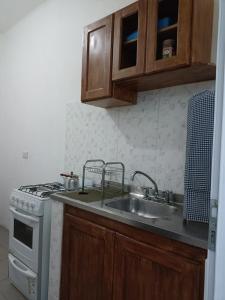 a kitchen with a sink and a stove at Filipo Departamento in Paso de los Libres