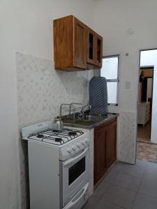 a kitchen with a white stove and a sink at Filipo Departamento in Paso de los Libres