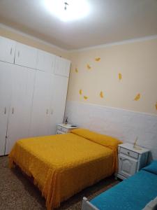 a bedroom with two beds with yellow sheets and butterflies on the wall at Filipo Departamento in Paso de los Libres