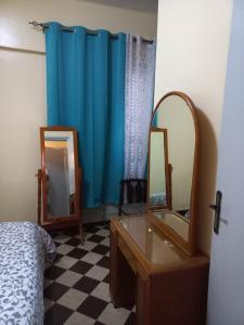 ein Schlafzimmer mit einem Spiegel, einer Kommode und einem Waschbecken in der Unterkunft Appartement sympathique Jules Ferry. in Dakar