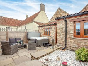 a patio with a hot tub in the backyard of a house at Daisy Cottage - Uk31294 