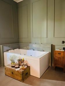una grande vasca bianca in una stanza con pareti verdi di Dimora Terranova Charming Rooms a Noto