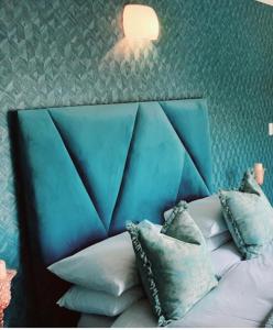 a bed with a blue head board with pillows on it at Boutique Stay in Johannesburg