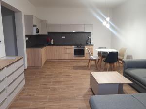 een keuken en een woonkamer met een bank en een tafel bij Penzion Vilma in Smilovice