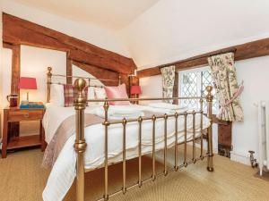 een slaapkamer met een bed en een raam bij Pollard Cottage in Lingfield