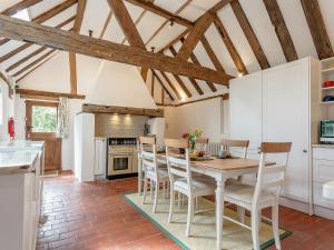 a kitchen with a dining room table and chairs at Pollard Cottage in Lingfield