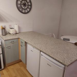 a kitchen with a counter top and a clock on the wall at Lovely 2-Bed Apartment in Milton Keynes in Milton Keynes