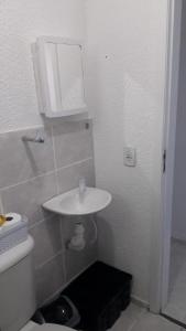 a bathroom with a white sink and a toilet at Espaço do Adilson é aconchegante in Rio de Janeiro
