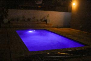 a swimming pool with blue lighting in a room at night at Senaville Guesthouse in Louis Trichardt