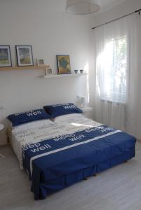una camera da letto con un letto con lenzuola blu e una finestra di Da Irene a Mestre