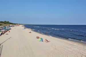 a beach with people laying on the sand and the ocean at Ferienhaeuser Zinnowitz USE 1760 in Zinnowitz