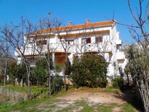 a white house with a red roof at Apartments Krešimir beauty with shadow trees and parking place in Pag