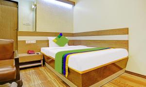 um pequeno quarto com uma cama e um espelho em Treebo Trend Hiramani Parel Lalbaug em Mumbai