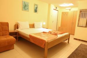 una piccola camera con letto e sedia di Hotel North City a Kosovska Mitrovica