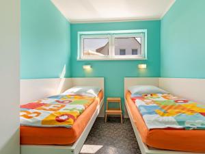 two beds in a room with blue walls at Beautiful Seaside Holiday Home in Zierow in Zierow