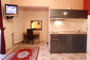 a kitchen with a desk and a tv on the wall at Hotel North City in Mitrovicë