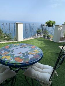 a table and two chairs on a lawn with a table at Gresy Appartamento Suite in Positano