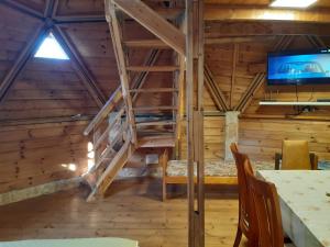 בקתת עץ בחורש במנות - דום גיאודזי - Wooden cabin in Manot في Manot: غرفة مع درج في كابينة خشب